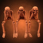 Lot de trois squelettes décoratifs assis à jambes pendantes