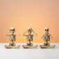 Lot de trois squelettes décoratifs assis à jambes pendantes